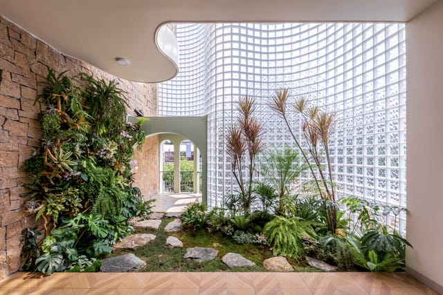 casa de 465 metros con fachada de ladrillo de vidrio, jardines interiores y soluciones pasivas