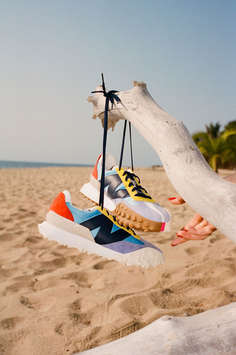 a staud new balance sneaker hanging on a beach from the staud new balance collaboration