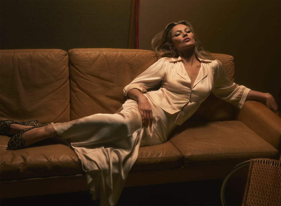 a person reclining on a sofa in a silky ivorycolored dress