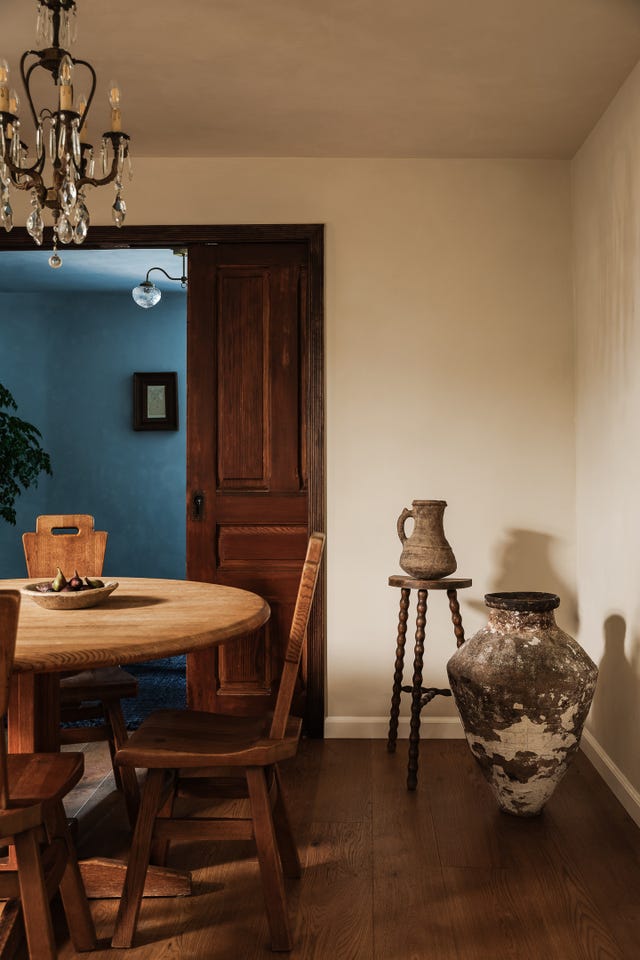 rustic dining area with wooden table and chairs antique pottery and a doorway