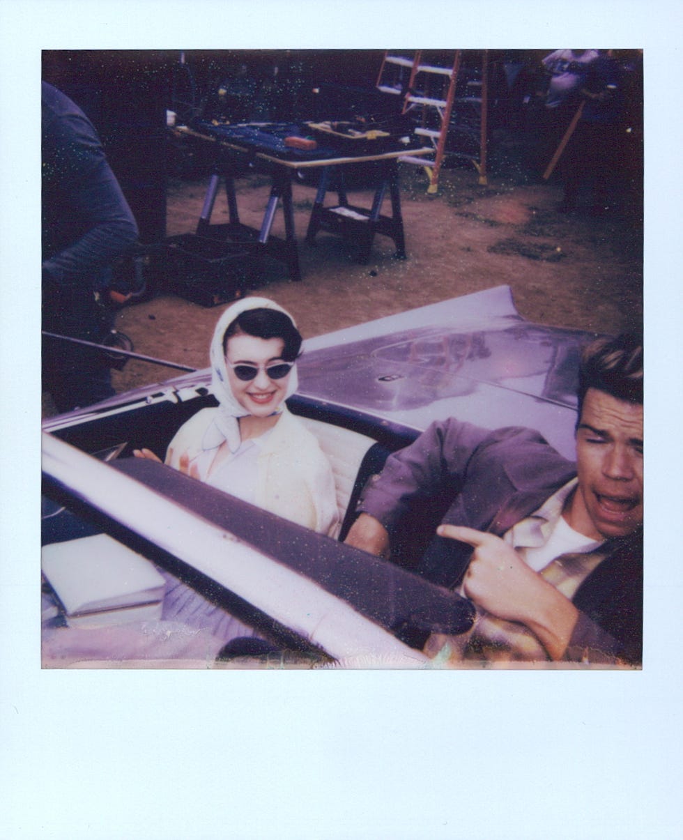 a convertible car with two occupants inside