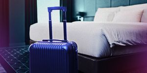 suitcase parked next to a hotel bed