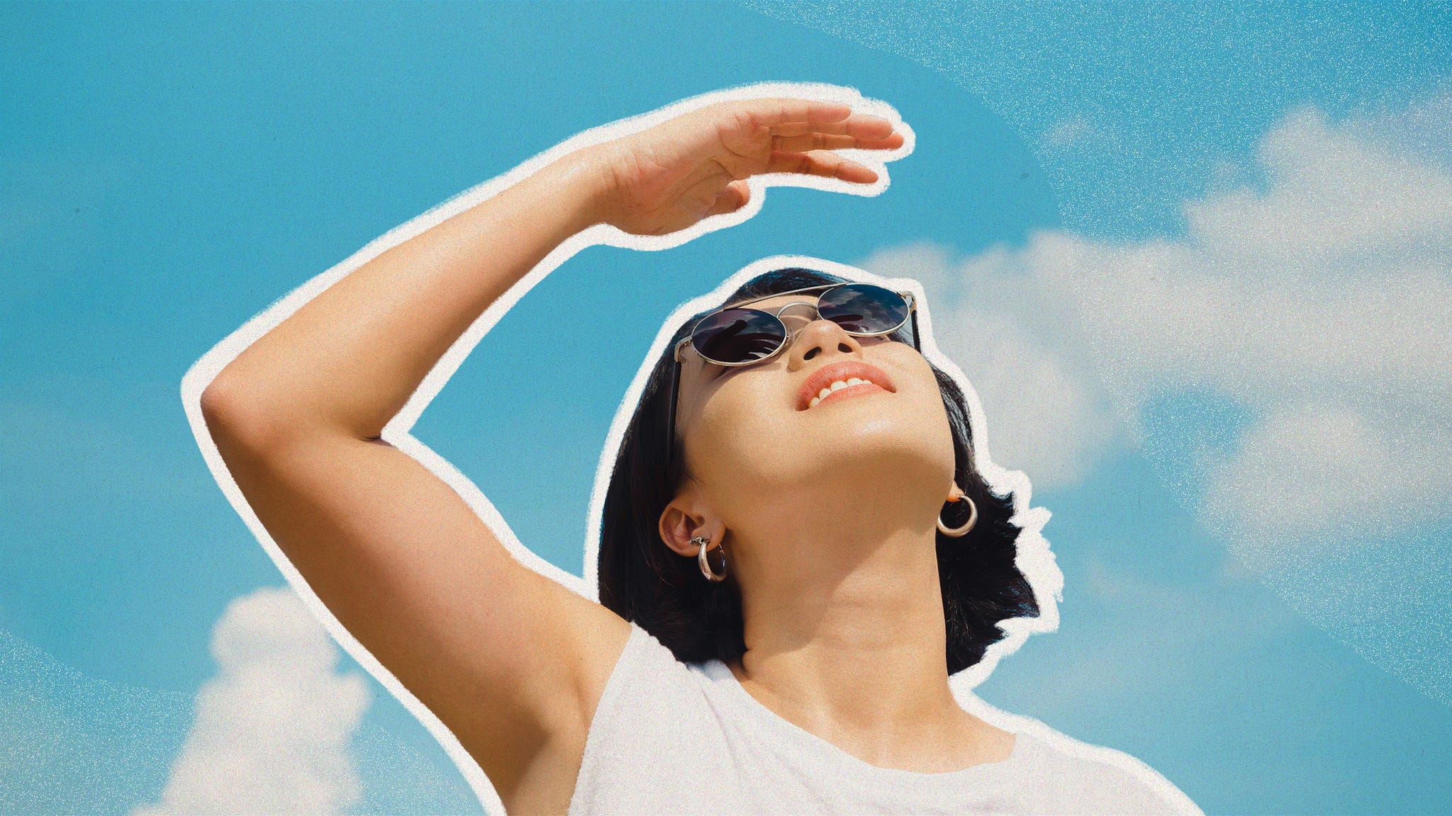 woman looks up at the sun with sky in the background