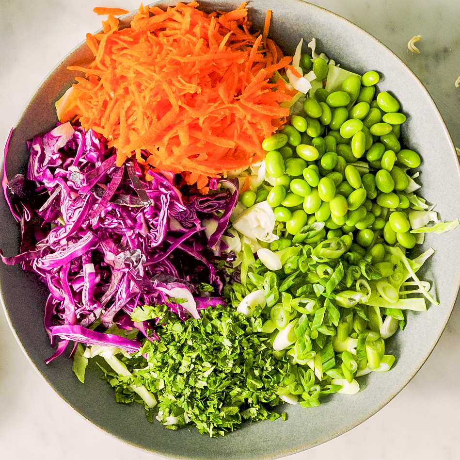 cabbage, carrots, edamame, and cilantro in a bowl
