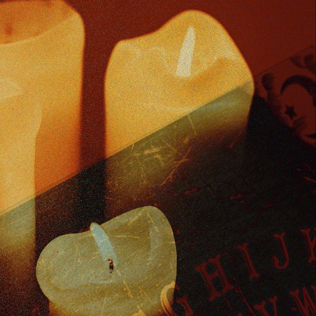 candle illustration with ouija board lettering