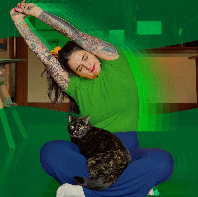 a woman stretching and mediating with a cat in her lap