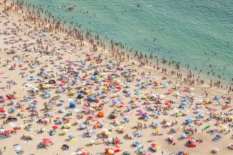 NAZAR PORTUGALHet populaire strand van Nazar is omgetoverd in een caleidoscopisch tableau van parasols en badhanddoeken Het stadje was ooit een bekende vissersplaats maar is nu een van de meest geliefde badplaatsen van Portugal