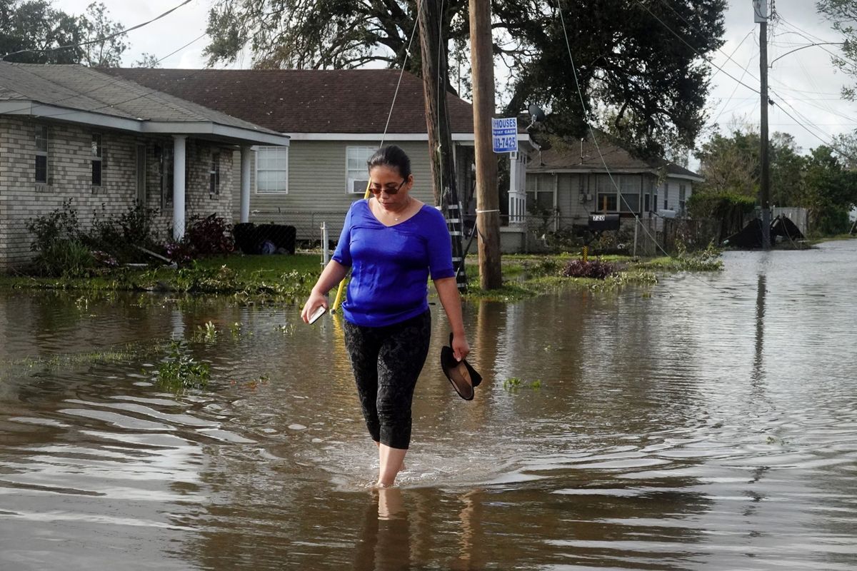 Angelina Coxum loopt door een straat in Kenner Louisiana om het huis van een familielid te gaan controleren De straat is ondergelopen door de zware regenval tijdens hurricane Ida die afgelopen zondag als een storm van categorie 4 aan land kwam De nasleep ervan waaronder overstromingen en stroomstoringen kan nu pas worden beoordeeld