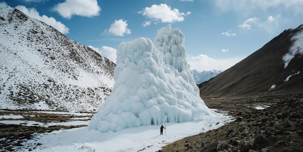 https://i.natgeofe.com/n/1cae184c-16e0-414e-b7b8-05a4e5590f0e/001_The-Ice-Stupas-Ciril-Jazbec-high-res.jpg in de noordindiase regio ladakh torent een enorme toren van ijs een zogenaamde ijsstoepa hoog boven een man uit terwijl het sneeuwpak in het hooggebergte steeds sneller afsmelt en gletsjers zich terugtrekken worden dit soort stoepas opgebouwd om water in bevroren vorm op te slaan met deze 335 meter hoge ijstoren bij het dorp shara phuktsey wonnen de dorpelingen de prijs voor de beste ijsstoepa het bouwwerk bevat zevenenhalf miljoen liter water waarmee akkers rond vier dorpen gerrigeerd kunnen worden