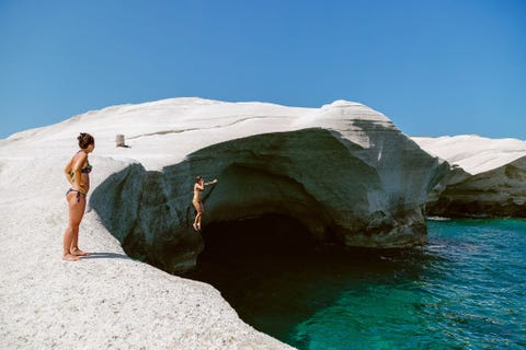 MILOS GRIEKENLANDEen rotsduiker bereidt zich voor op een stevige plons in het turkooizen water van de Egesche Zee Het maanlandschap van het Sarakinikostrand is gevormd door decennia van opgezweepte golven die het vulkanische gesteente van het eiland in buitenaardse vormen hebben uitgesleten