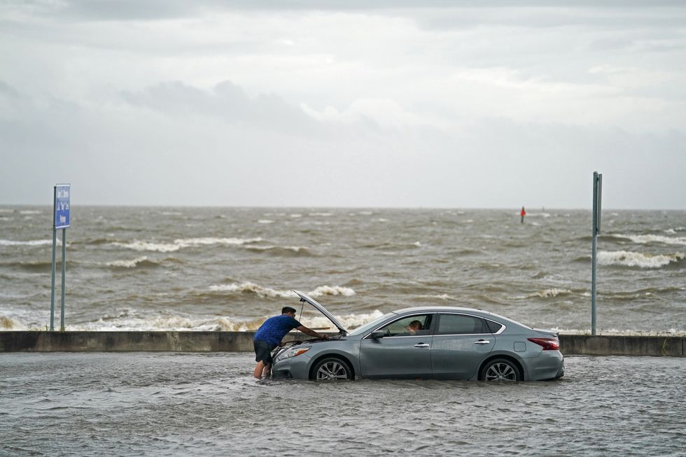 Een man helpt een automobilist die is gestrand op de ondergelopen Beach Boulevard in Biloxi Mississippi Hurricane Ida kwam in Louisiana aan land en leidde aan de Amerikaanse kust van de Golf van Mexico tot wijdverspreide overstromingen en stormschade