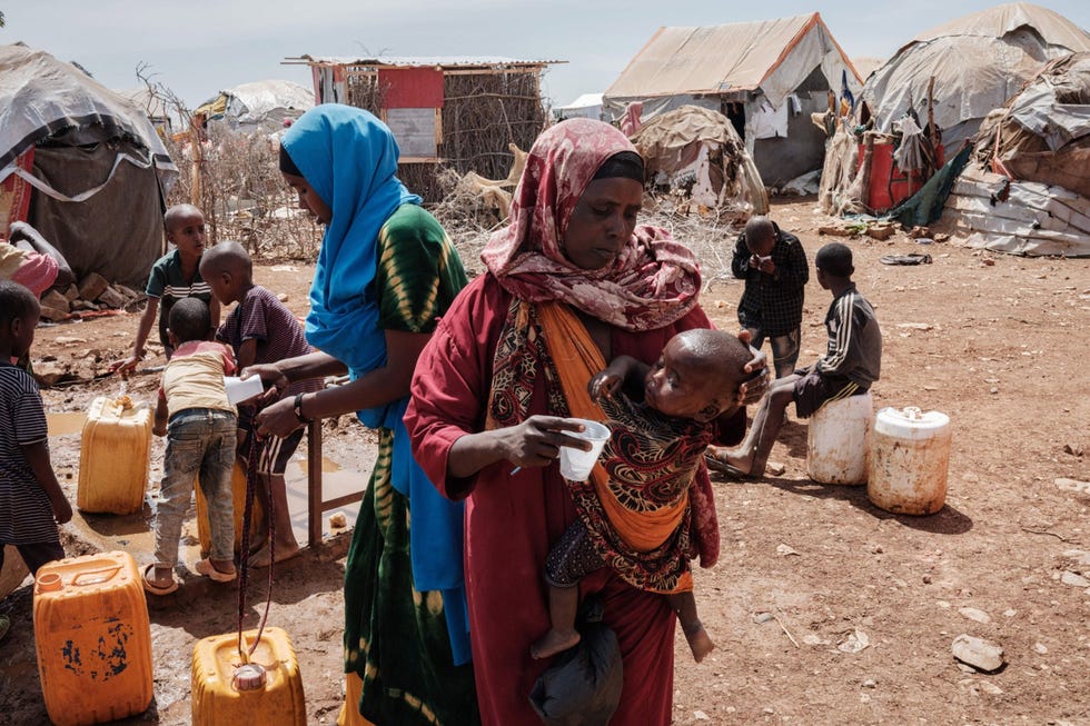 In Tawkal 2 Dinsoor een vluchtelingenkamp voor intern ontheemden bij Baidoa Somali geeft Bulley Hassanow Alliyow haar kind te drinken Wanhopig en geplaagd door honger en dorst trekken steeds meer mensen van het ZuidSomalische platteland naar Baidoa