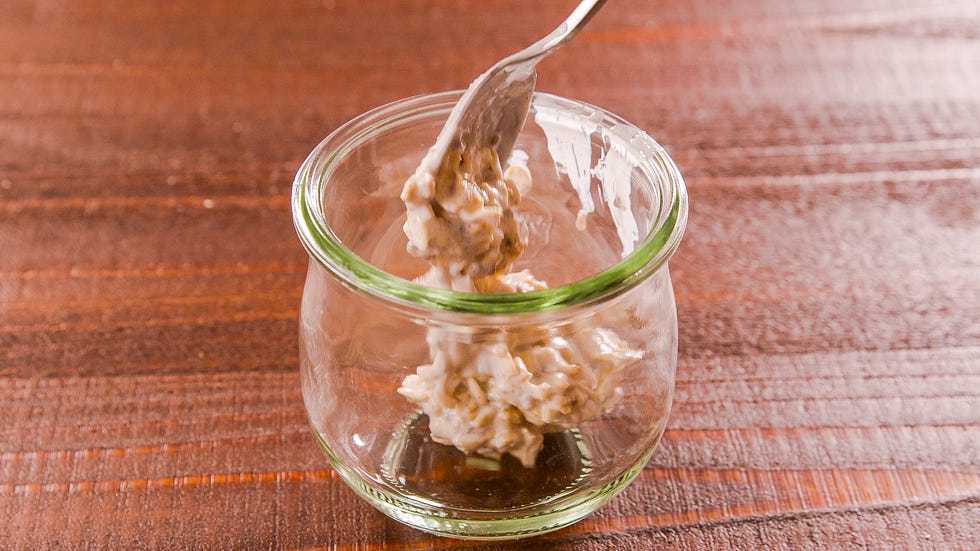 spooning overnight oats into a jar