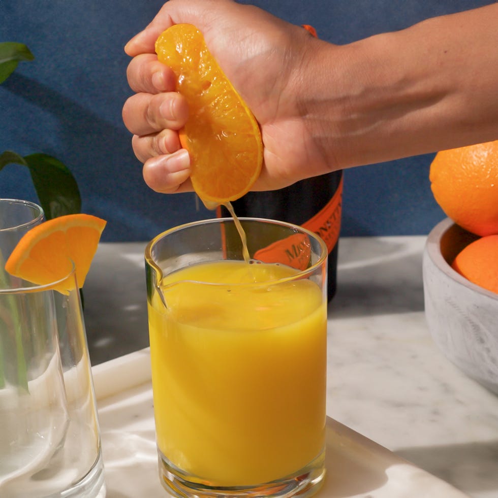 squeezing orange juice into glass