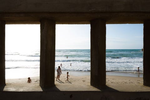 CEFAL ITALIEen moeder en haar kinderen spelen op het gouden strand bij Cefal Gelegen aan de noordkust van Sicili is Cefal een badplaatsje op ongeveer een uur rijden van de Siciliaanse hoofdstad Palermo