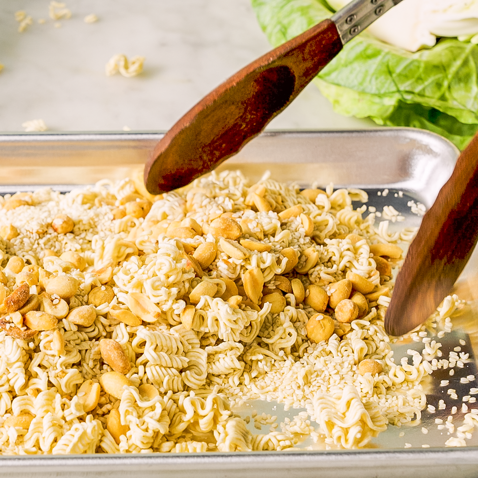 mixing ramen noodles, nuts, and sesame seeds