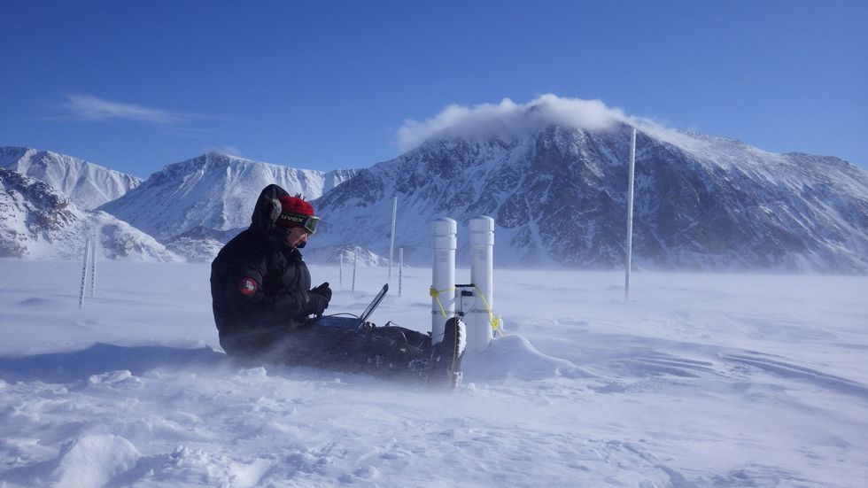 Trevor Bell een van de oprichters van SmartICE voert een upgrade door van de software op een SmartBUOY waarmee de ijsdikte van het pakijs in de Eclipse Sound bij Pond Inlet Nunavut wordt gemeten