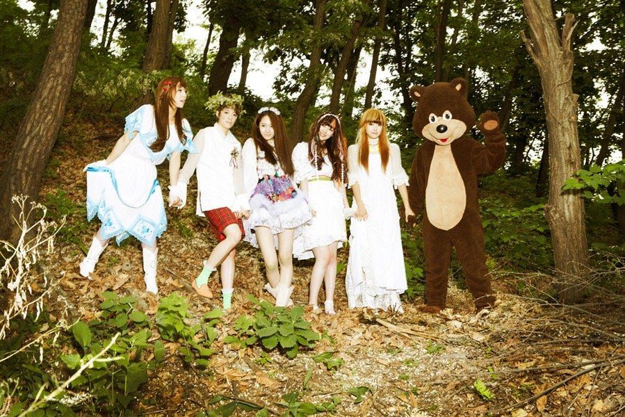 a group of people posing for a photo with a person in a bear garment