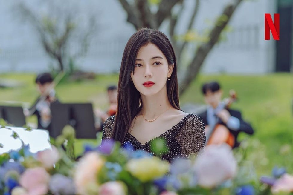 a woman sitting in a field of flowers