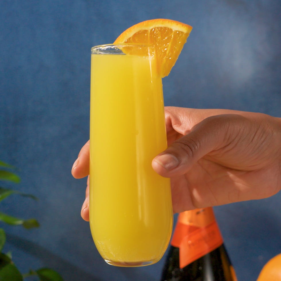 holding a glass of mimosa