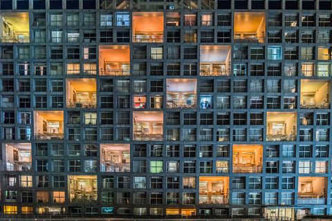 Kleurige verlichting contrasteert met de donkere ramen van een appartementengebouw aan de Baai van Tokioin Japan Tokio de grootste stad van Japan heeft ruim negen miljoen inwoners en een groot deel van hen kiest ervoor om in een appartement te wonen