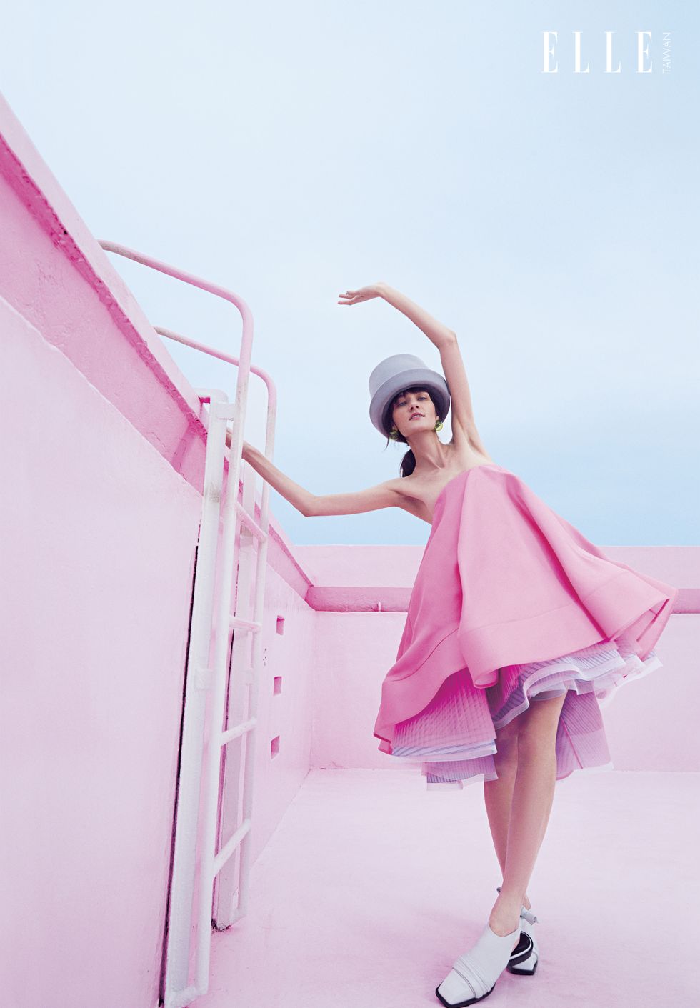一個女人穿著粉色洋裝抓著梯子