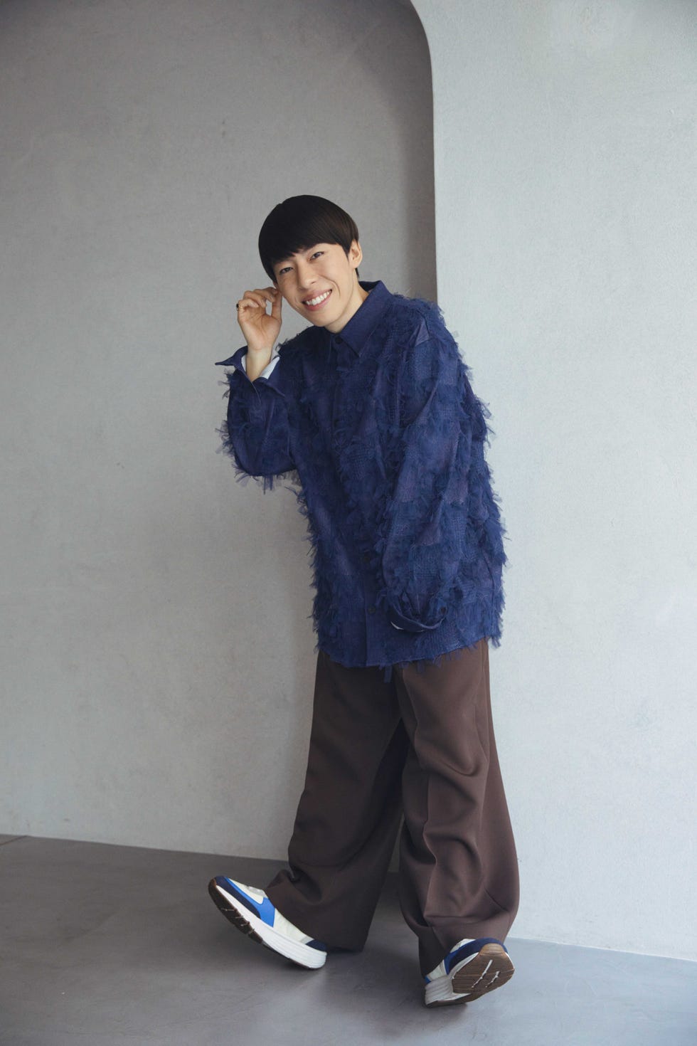 a person wearing a blue sweatshirt and hat and holding a cigarette