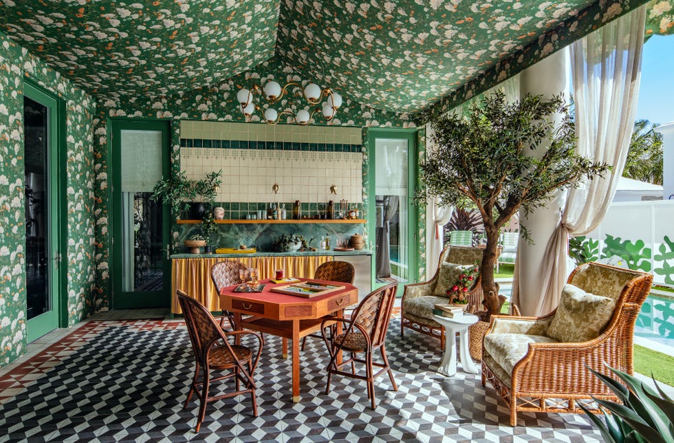 a green pavilion with a dining table and a bar