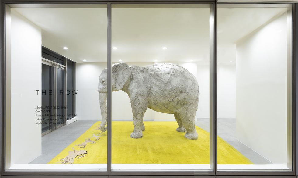a statue of an elephant in a room with glass doors
