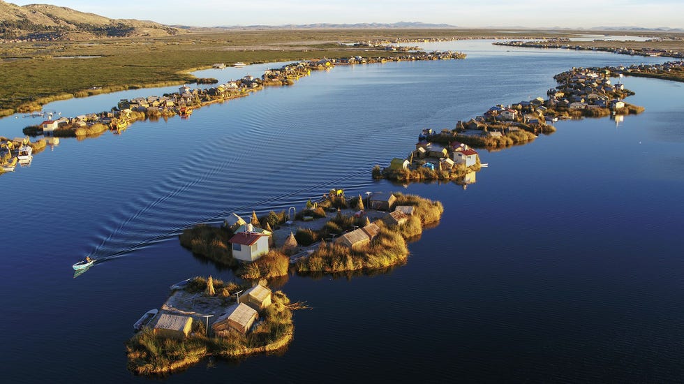 TITICACAMEER PERU  De leden van het Urovolk die aan de oevers van het Titicacameer in Peru leven hebben hun dorpen in de loop van tijd op vaste grond gevestigd door hun boothuizen van riet met elkaar te verbinden en aarde van het vasteland te gebruiken om ketens van eilandjes met akkerland te creren