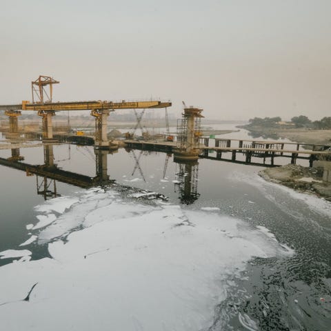 Naburige fabrieken dumpen hun chemisch afval in de de rivier de Jamuna die daardoor is bedekt met een laag giftig schuim