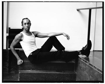 a person posed casually while sitting on steps wearing casual clothing