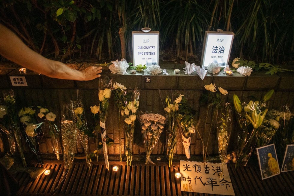 Bij een gemproviseerd gedenkteken in Hongkong herdenkt een vrouw de demonstrant Marcus Leung die in 2019 tijdens protesten tegen de Chinese uitleveringswet omkwam