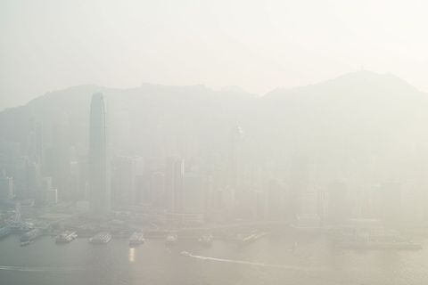 Door een mist van vervuiling is de skyline van Hongkong te zien op 9 januari 2017 Op zondag bereikte de luchtvervuiling een gevaarlijk niveau in Hongkong dat erg grote gezondheidsrisicos met zich meebracht Oorzaak was een moessonwind uit het noordoosten die smog vanuit het vasteland de stad in blies