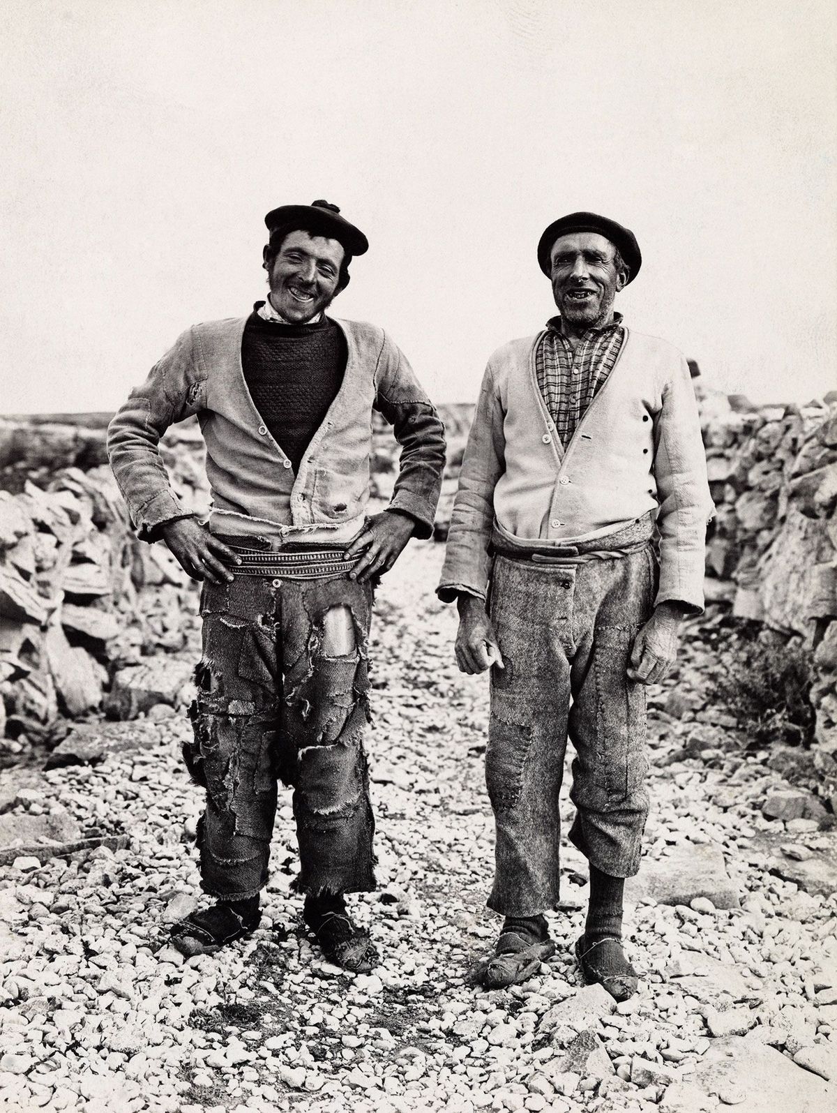 Twee Ierse zeewierbranders staan op een rotskust en lachen voor de foto 1915
