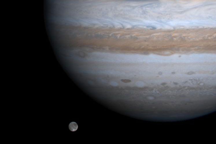 Op deze foto van de NASAsonde Cassini lijkt de grootste maan in ons zonnestelsel Ganymedes naast Jupiter in de ruimte te zweven Astronomen hebben nu vanaf de aarde een dozijn nieuwe maantjes rond Jupiter gevonden wat het totale aantal manen rond deze gasreus op 79 brengt