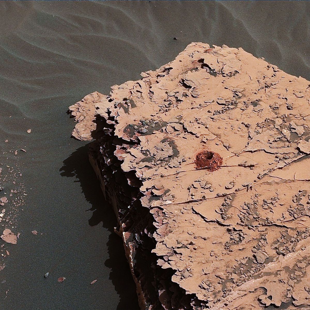 De Curiosity rover van de NASA boorde dit 5 centimeter diepe gat in een stuk steen op Mars in het kader van het onderzoek naar de bodemsamenstelling van de planeet