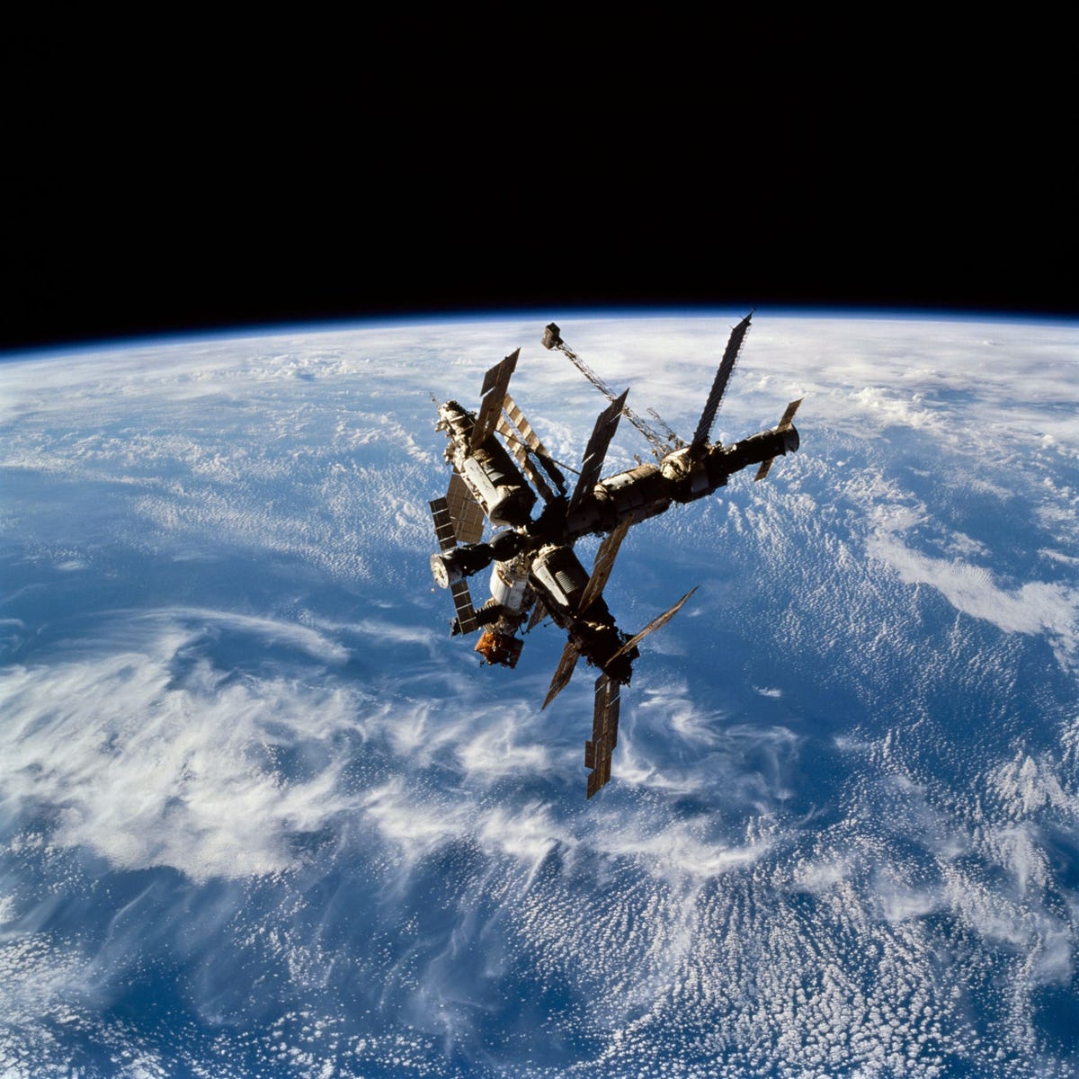 De eerste astronauten op de Mir noemden het ruimtestation Dragonfly Libelle en op deze foto die in 1995 vanuit de spaceshuttle Atlantis werd genomen is goed te zien waarom De aangedokte ontsnappingscapsule Sojoez is links te zien de eveneens aangedokte vrachtcapsule Progress uiterst rechts