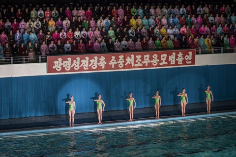 Jonge vrouwen staan klaar voor hun optreden als synchroonzwemmers op een viering in Pyongyang NoordKorea die deel uitmaakt van de 75e herdenking van de geboorte van de overleden NoordKoreaanse leider Kim Jong Il