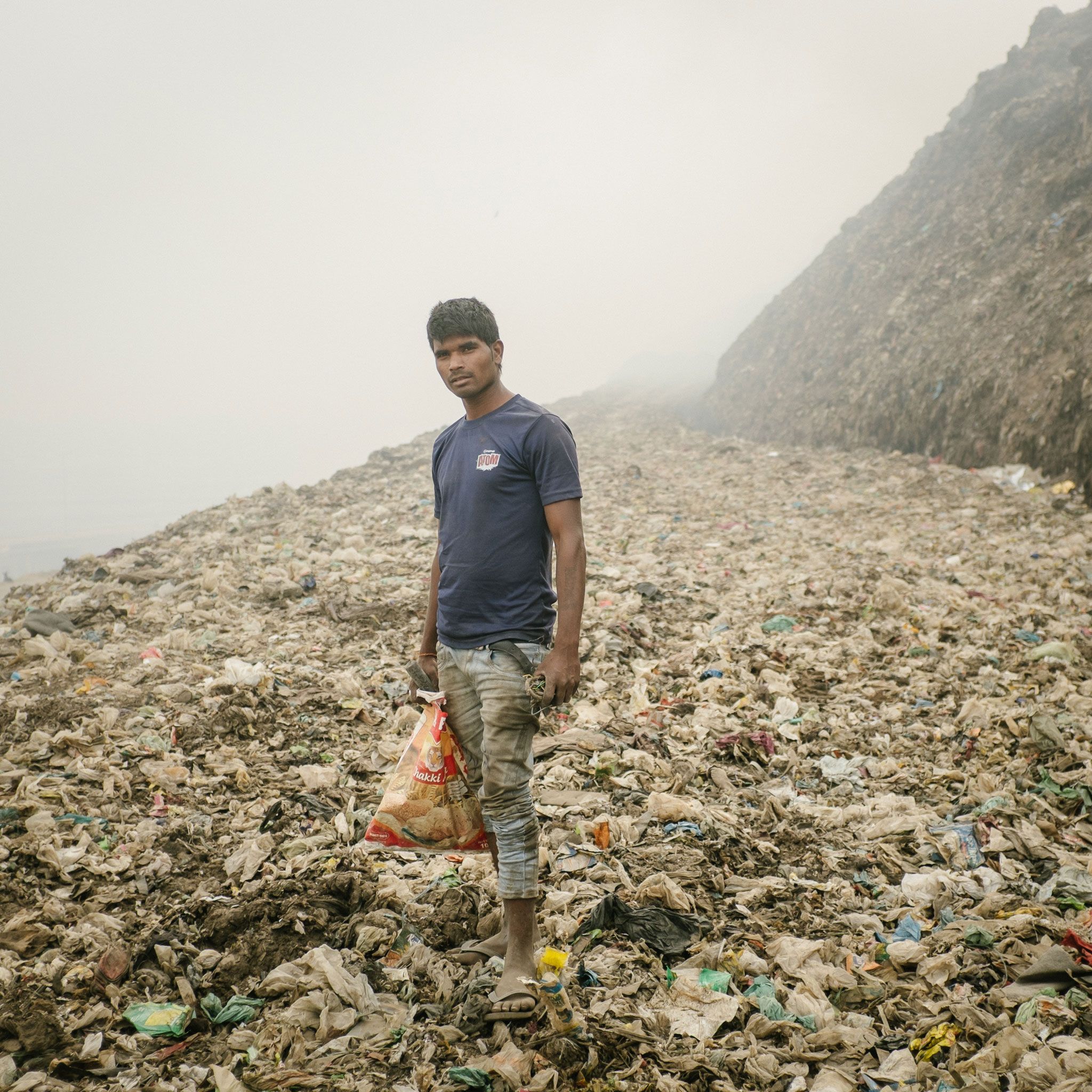 In Bhalswa zoekt een recyclingwerker metalen op een enorme vuilnisbelt die permanent brandt en giftige rook uitstoot