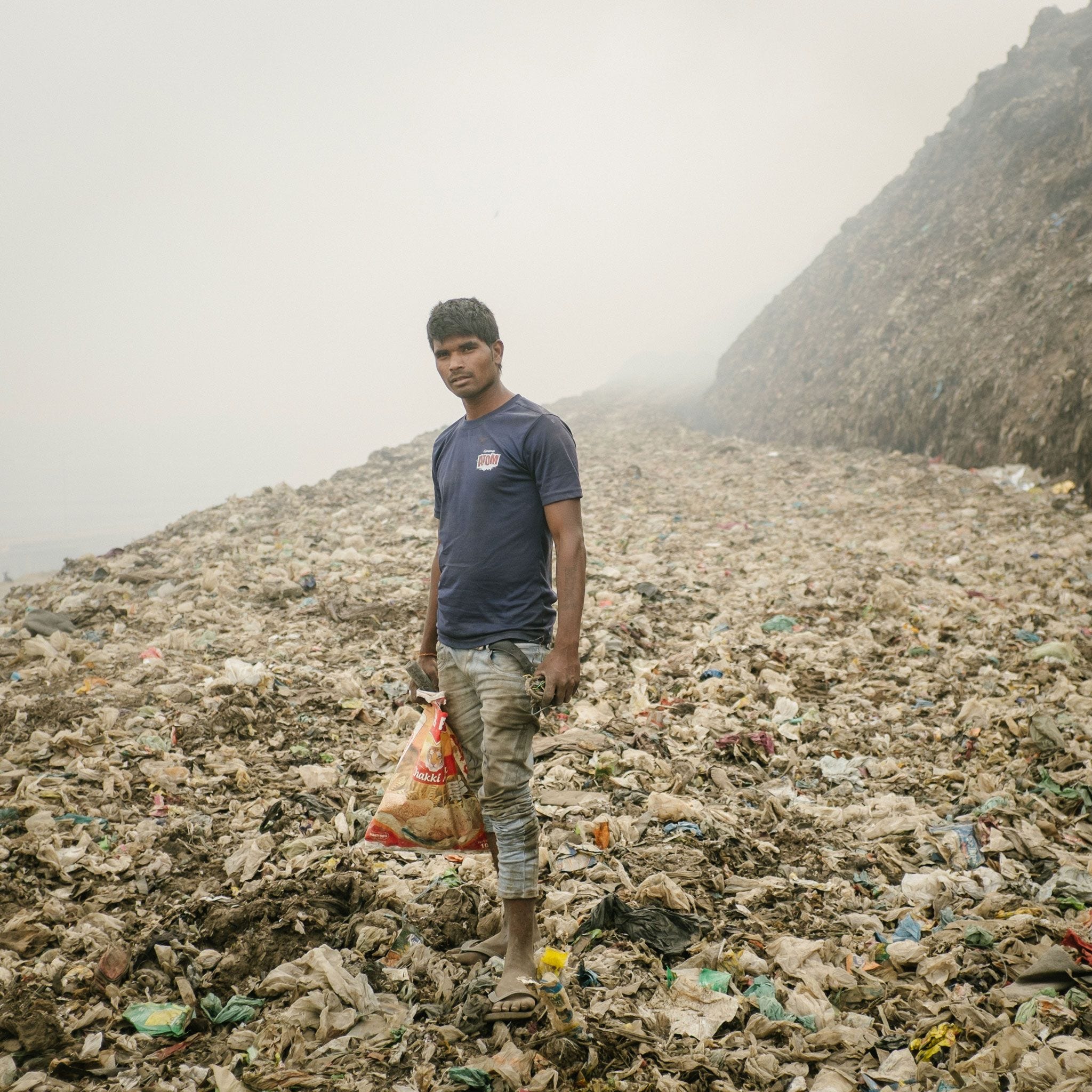 In Bhalswa zoekt een recyclingwerker metalen op een enorme vuilnisbelt die permanent brandt en giftige rook uitstoot