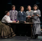 five suffragist women gathered around a table during a production of suffs five suffragist women gathered around a table during a production of suffs