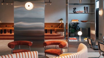 a lobby with silver walls and orange furniture