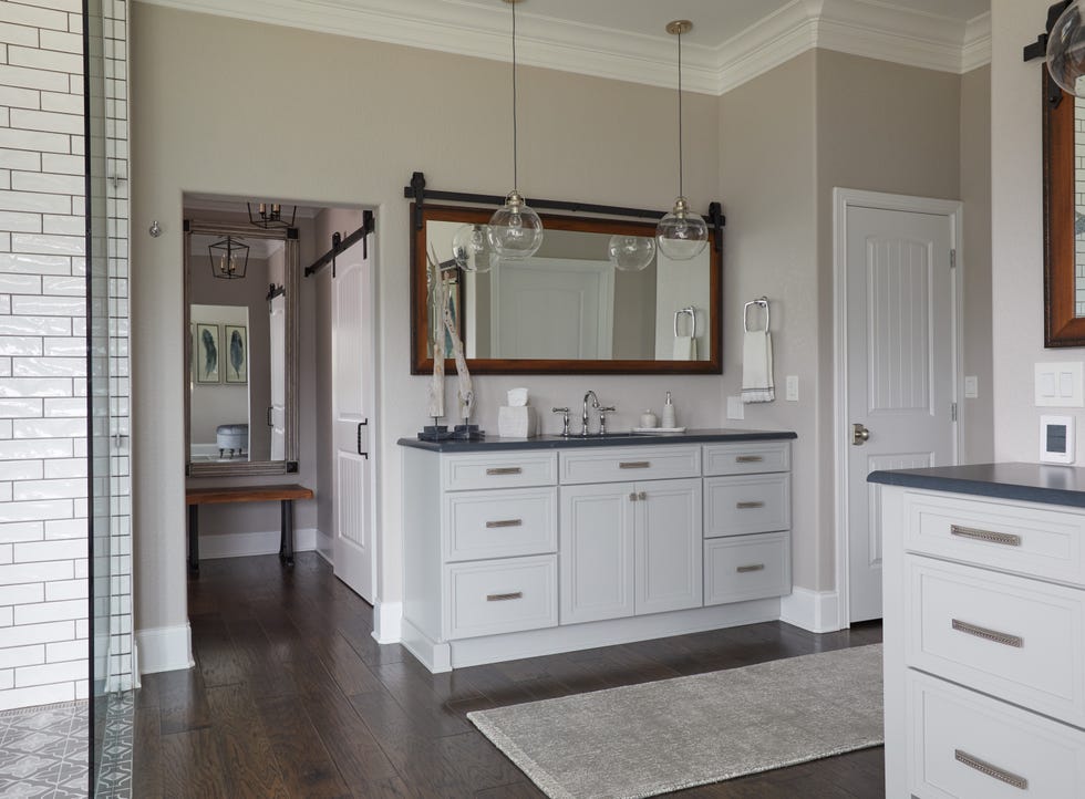 a white bathroom with marble top and mirror