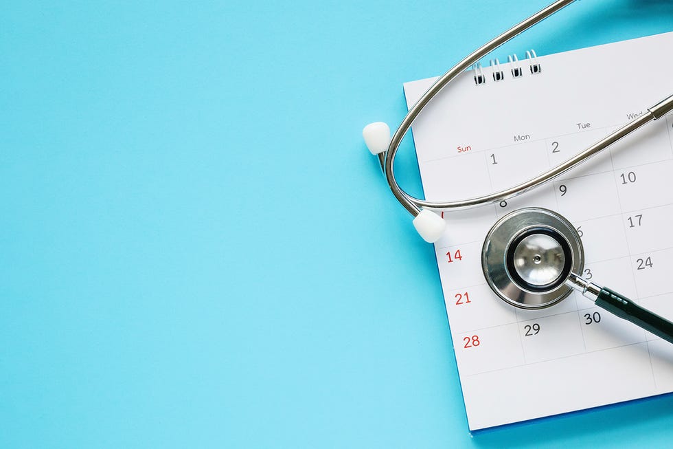 stethoscope with calendar page date on blue background doctor appointment medical concept