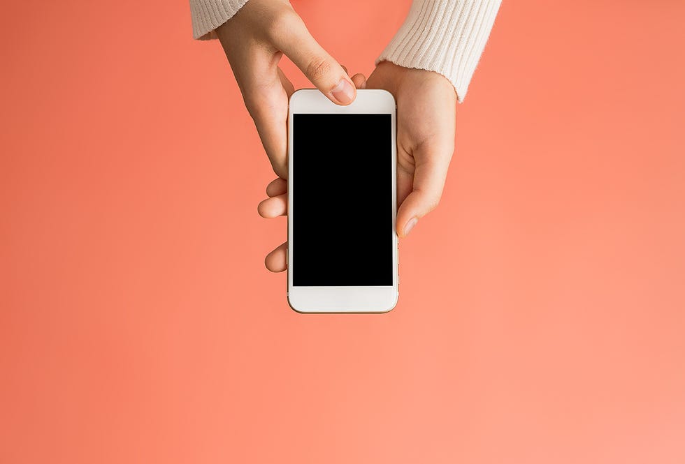 closeup of woman using mobile phone over pink background