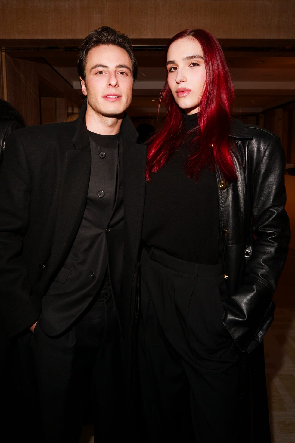 two individuals dressed in black attire at a social event