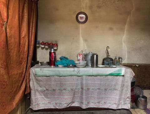 Een pan en wat borden op een tafel vormen deze gemproviseerde keuken in een huis in Aliabad Pakistan