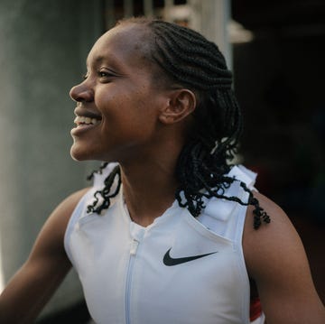faith kipyegon individual wearing athletic attire with braided hair in an outdoor setting
