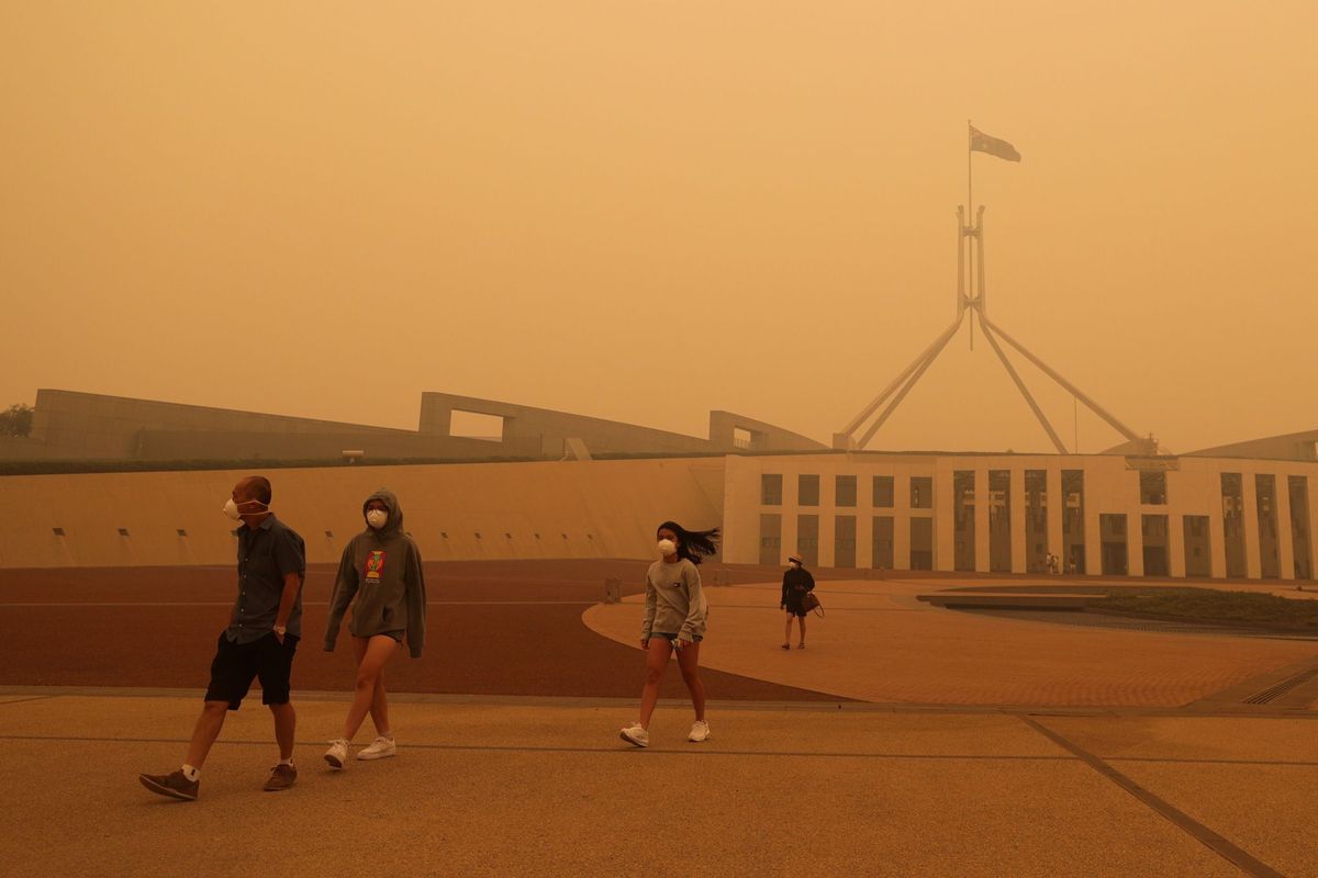Bezoekers aan Parliament House in Canberra dragen ademhalingsmaskers tegen de rook die bij de bosbranden is ontstaan en de Australische hoofdstad in een mist van roetdeeltjes heeft gehuld 5 januari 2020